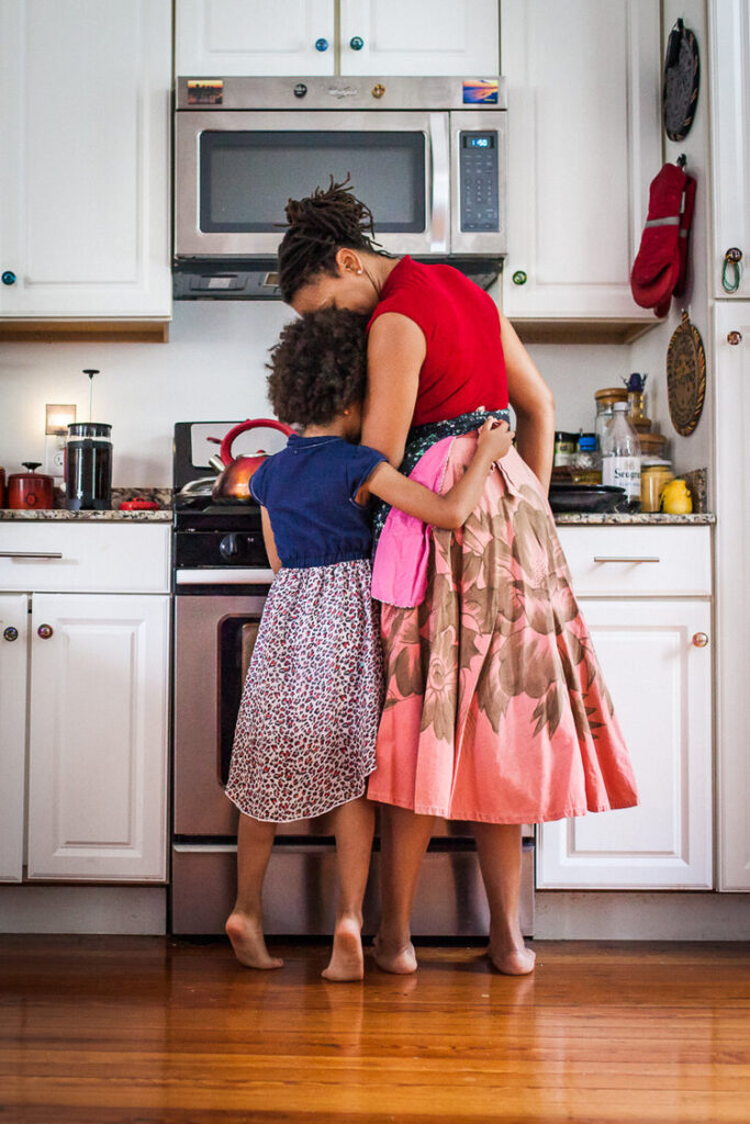 JUlie Verlinden - Candid photography of a mom and daughter hugging in the kitchen