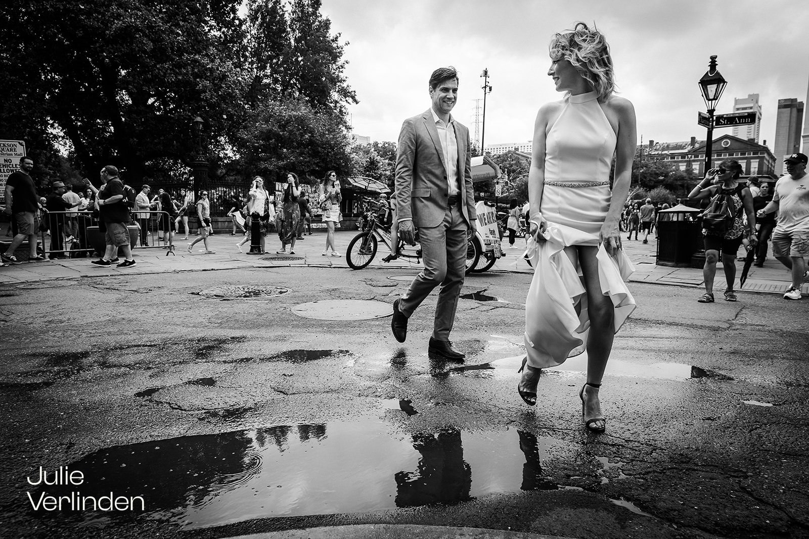 bride and groom walking around puddle by Jackson Square